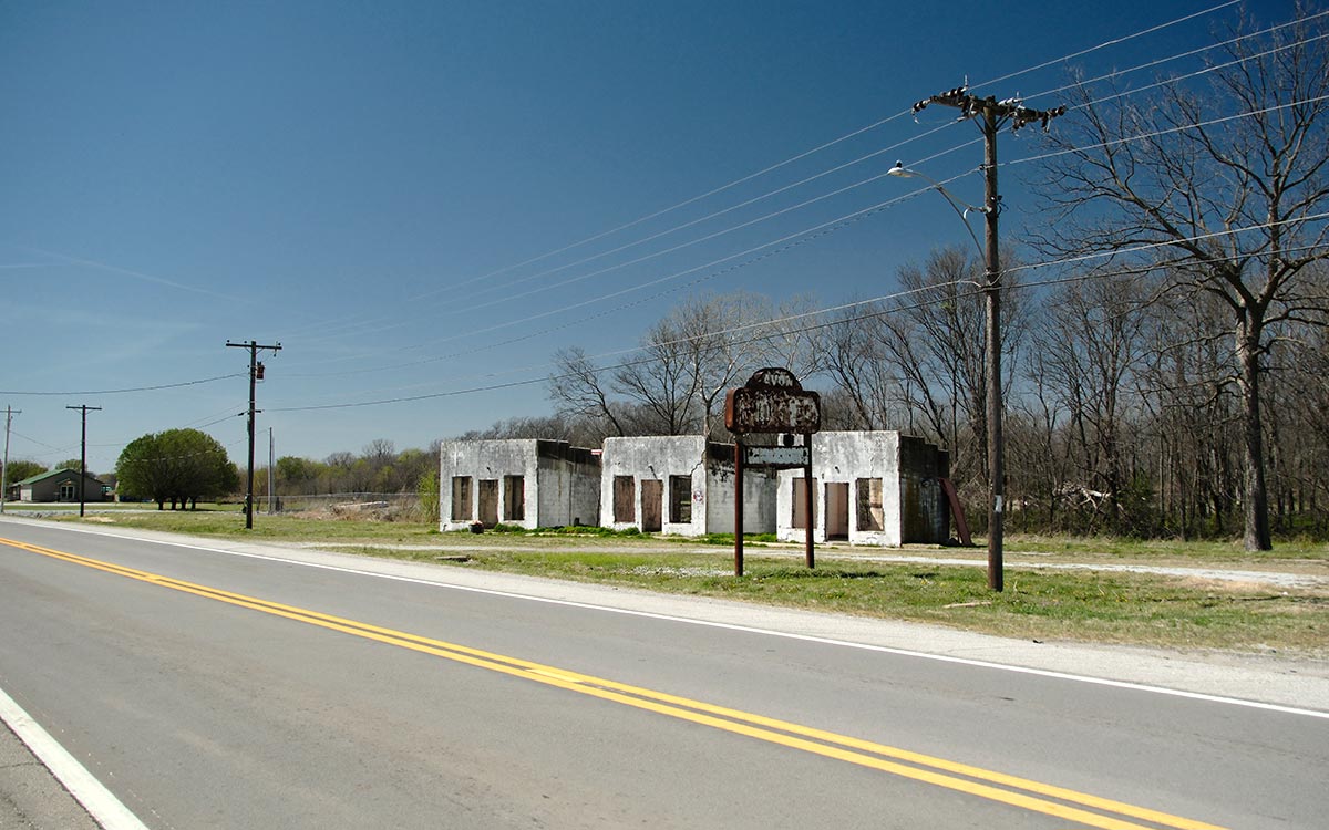 Las carcasas vacías de las antiguas cabañas del Avon Motel junto a un tramo tranquilo del camino