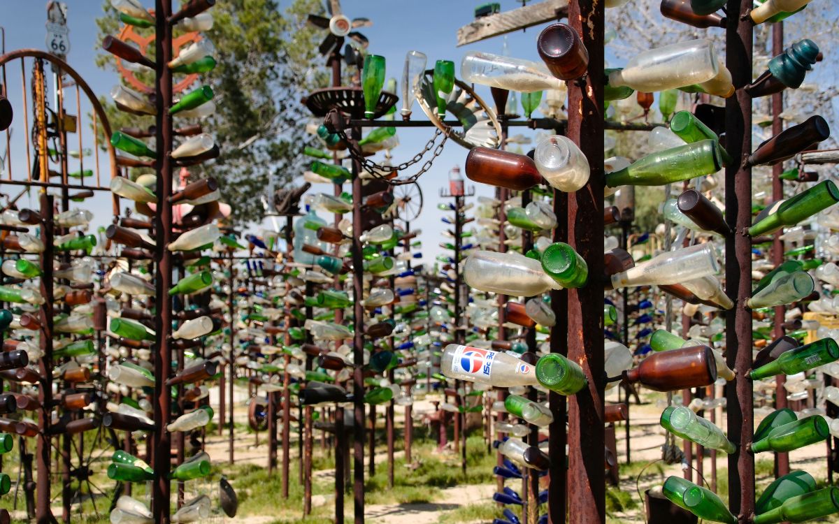 Cientos de botellas de vidrio de colores colgadas de árboles de metal en Elmer’s Bottle Tree Ranch