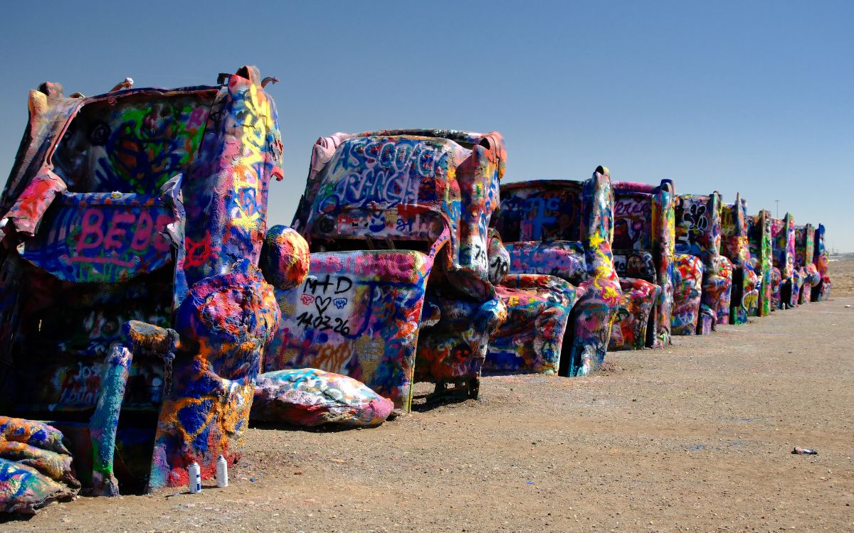 Una fila de Cadillac cubiertos de grafiti enterrados de trompa en un campo de Texas