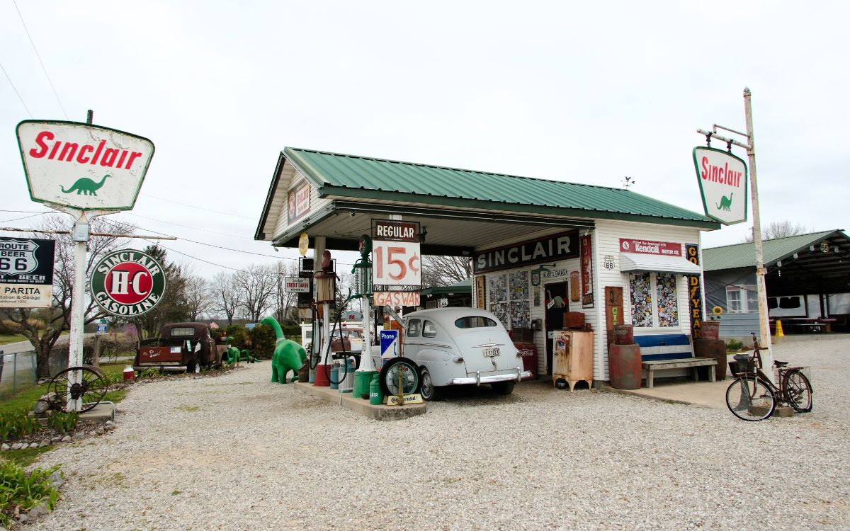 Gary’s Gay Parita, una estación Sinclair recreada con bombas antiguas, letreros, un auto viejo y un dinosaurio verde
