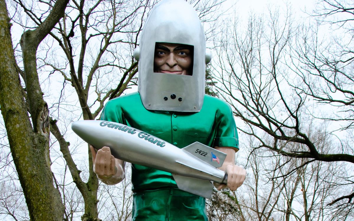 El Gemini Giant, un astronauta verde de fibra de vidrio con casco plateado que sostiene un cohete