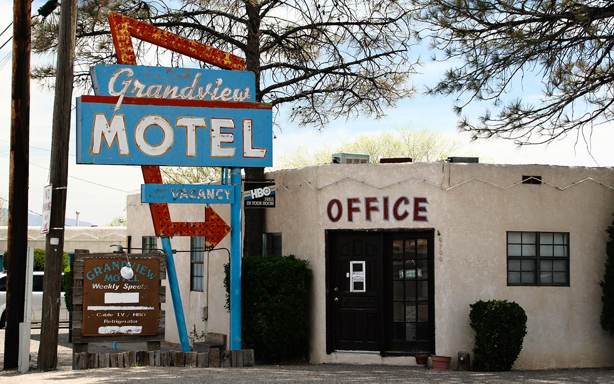 El letrero y la oficina del Grandview Motel, con una flecha de Vacancy y un tablero de ofertas semanales