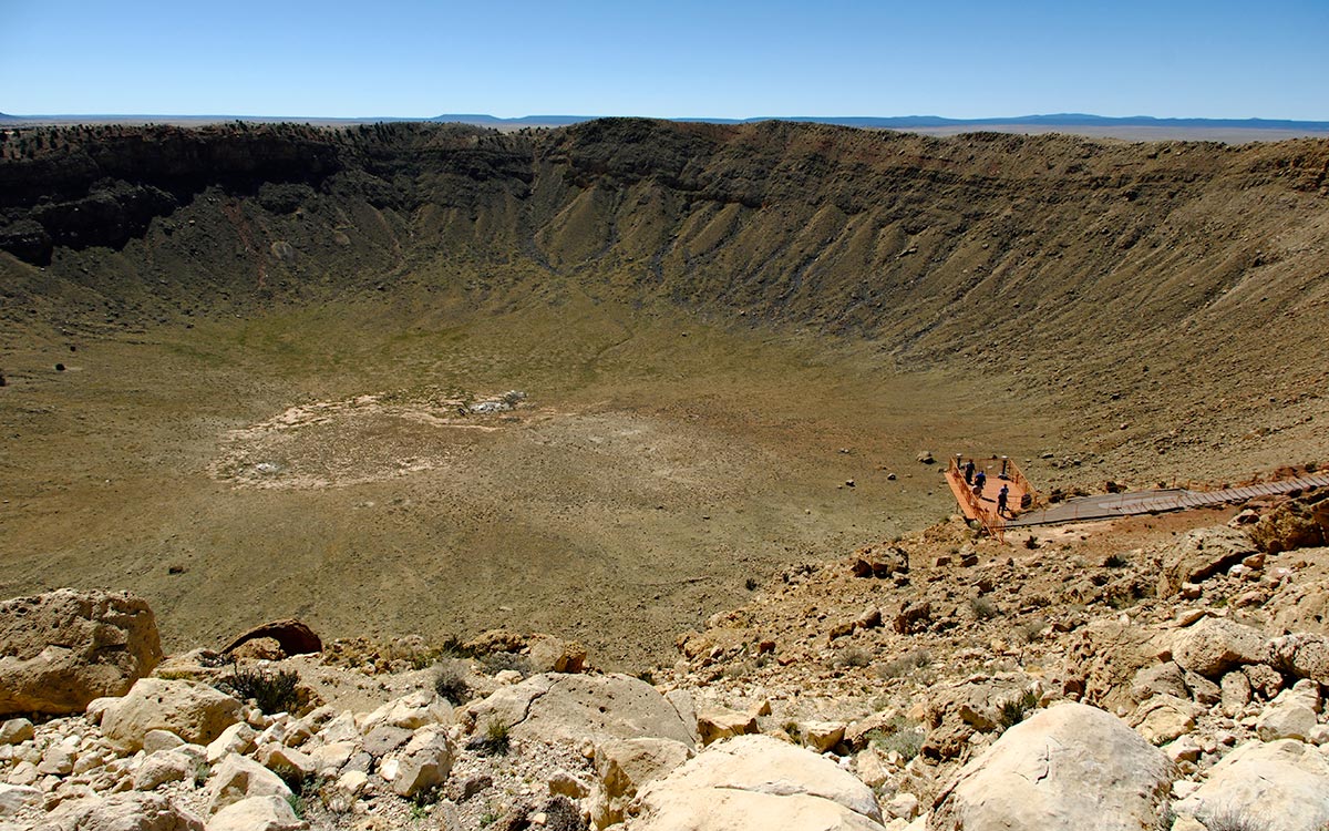 El borde y la cuenca de Meteor Crater en el desierto de Arizona, con una plataforma de observación en el extremo opuesto