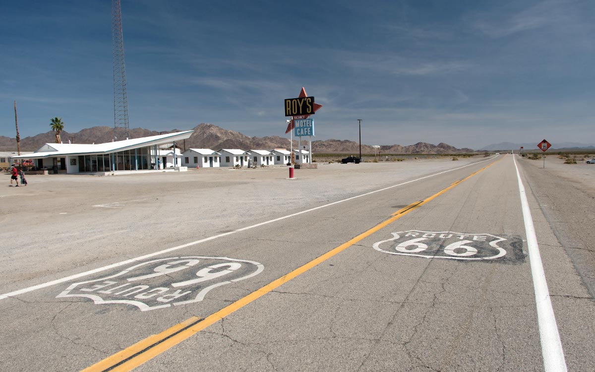 Roy’s Motel and Café in Amboy, California, beside Route 66 shields painted on the road