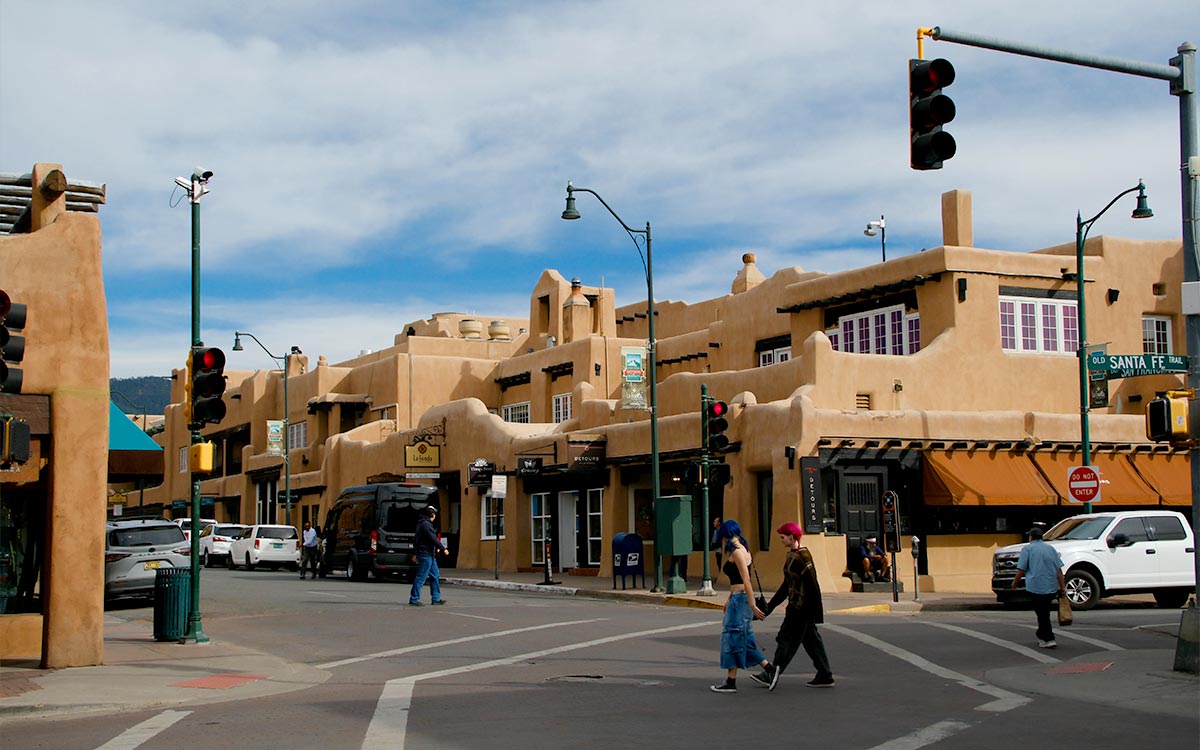 Una esquina del centro de Santa Fe, Nuevo México, bordeada de edificios de adobe y con un letrero de calle del Santa Fe Trail