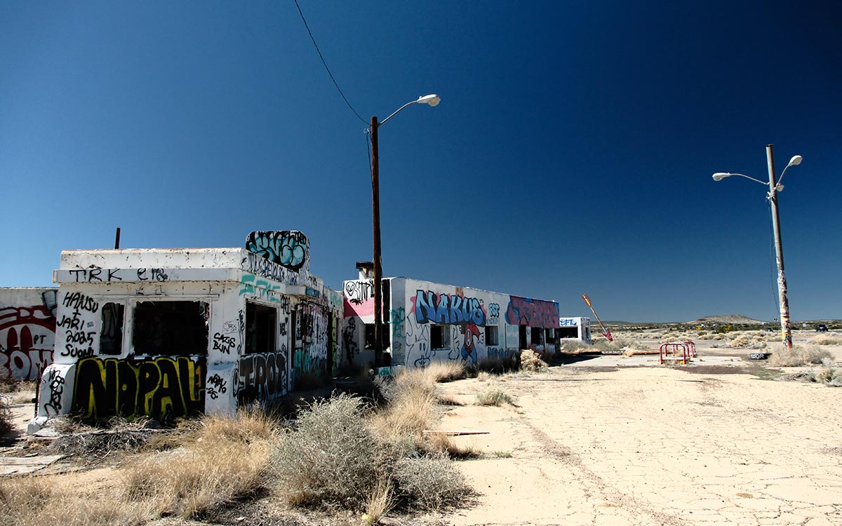 Los edificios abandonados de Twin Arrows, en Arizona, cubiertos de grafitis, bajo un cielo de un azul intenso