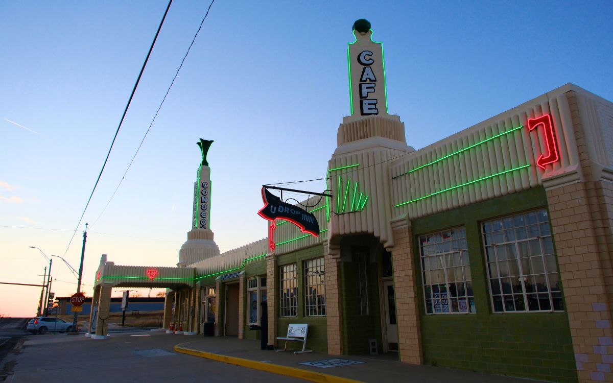 El U-Drop Inn Art Déco y la torre Conoco en Shamrock, Texas, con neón verde y rojo al atardecer